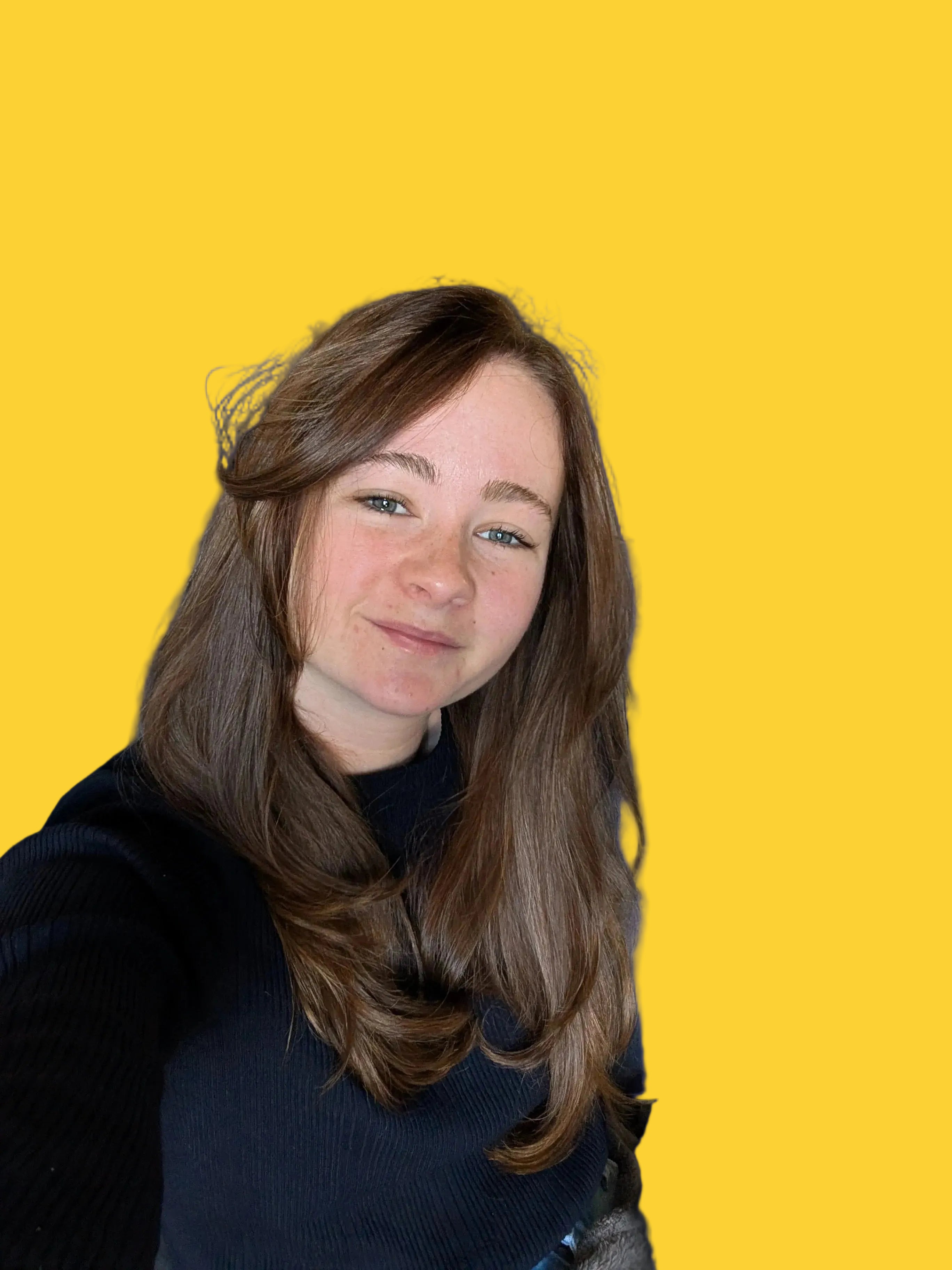 Smiling young woman with long brown hair sitting with an orange background.